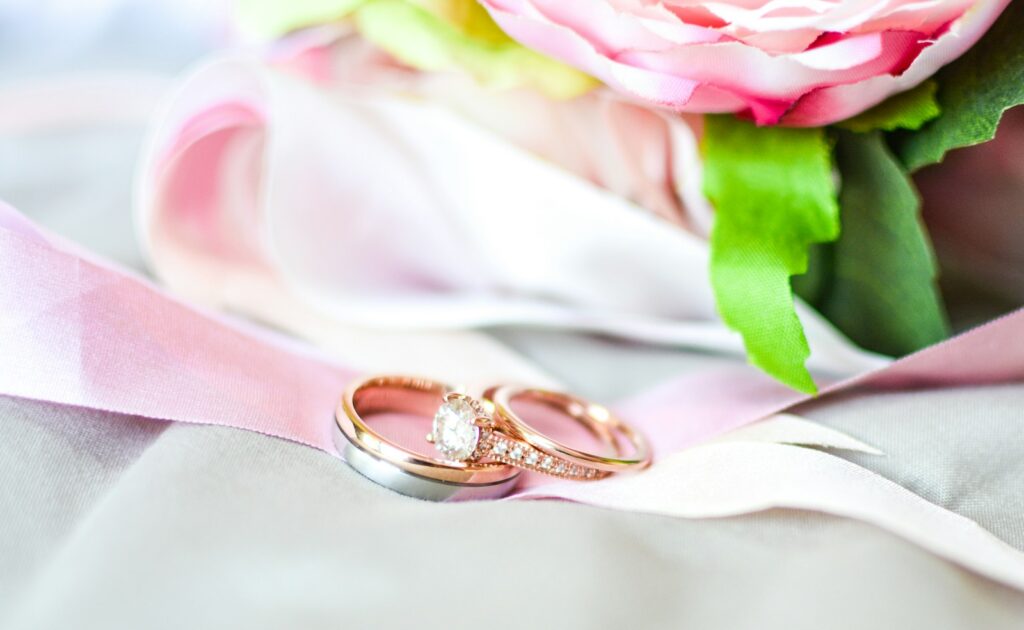 silver-and-gold-colored rings near pink flower